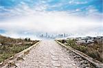 Stony path leading to misty cityscape