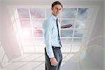 Smiling businessman standing with hand in pocket against airplane flying past window