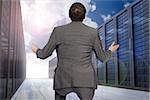 Businessman posing with hands out against server hallway in the sky