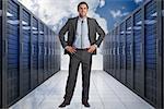 Smiling businessman with hands on hips against server hallway in the sky