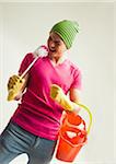 Young man having fun with colorful cleaning supplies, studio shot on white background