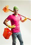 Portrait of young man holding colorful cleaning supplies, studio shot on white background