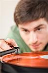 Young man playing vinyl record, close up