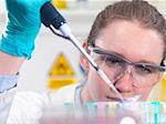 Scientist pipetting sample into an eppendorf vial in laboratory