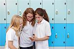 Three female school friends looking at mobile phone