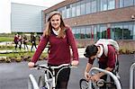 Teenagers unlocking cycles outside school