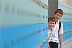 Portrait of two schoolboys behind lockers