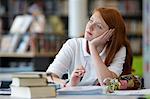 Portrait of teenage girl daydreaming in library