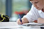 Close up of schoolboy writing in class