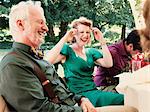 Newly married couple with parents laughing at wedding reception