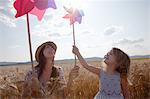 Mother and daughter in wheat field holding windmill