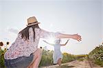 Girl running through field to mother with open arms