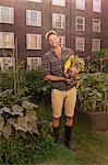 Mid adult man with harvested beetroot on council estate allotment