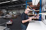 Worker checking quality of print products in printing workshop