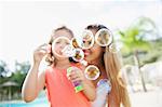 Mother and daughter blowing bubbles