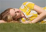 Portrait of young woman daydreaming on grass