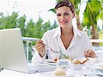 Portrait of young businesswoman having working lunch