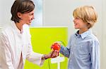 Dentist giving boy apple in dental reception