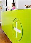 Medical reception desk with woman working in background