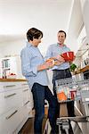 Adult grandson helping grandmother in kitchen