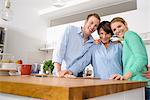 Portrait of youthful grandmother with adult grandchildren in kitchen