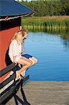 Young couple sitting next to lake, Gavle, Sweden