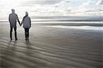 Young couple holding hands, Brean Sands, Somerset, England