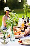 Friends barbecuing on the riverside, picnic table in foreground, Bavaria, Germany