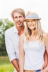 Happy young couple, woman with straw hat, Bavaria, Germany