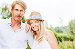 Happy young couple, woman with straw hat, Bavaria, Germany