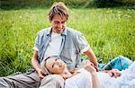 Happy couple relaxes in the meadow, foothills of the Alps, Bavaria, Germany