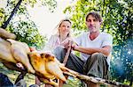 Young couple barbecuing on the riverside, foothills of the Alps, Bavaria, Germany