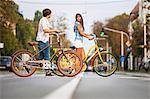 Young couple pushing bicycles together, Osijek, Croatia