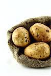 potatoes in burlap sack on white background