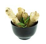 Fresh Ginger root in black bowl on a white background