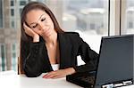 Businesswoman sitting at her desk tired and sleepy in an office