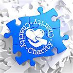 Charity Word Written Arround Icon of Heart in the Hand, Located on Blue Puzzle. Social Concept.