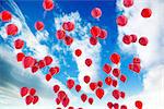 Red balloons floating over the blue sky