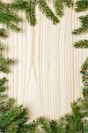 christmas background from fir twigs on wooden table, vertical