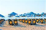 neat rows of sun loungers on the beach