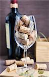 Wine glass with corks with bottle on the background