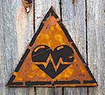 Icon of Heart with Cardiogram Line on Weathered Triangular Yellow Warning Sign. Grange Background.