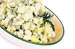 Delicious Freshly Made Creamy Potato Salad in Beige Rustic Bowl closeup on white background