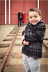Young Adorable Mixed Race Boy at Train Depot with Parents Smiling Behind.