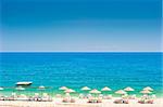 empty beach with white wicker umbrellas