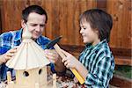 Father and son building a bird house or feeder for the winter time