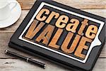 create value - inspirational text in vintage letterpress wood type on a digital tablet with a cup of coffee