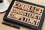 courage, consistency, competency in vintage letterpress wood type on a digital tablet with a cup of coffee