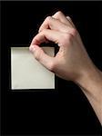 adult man hand holding sticky note, isolated on black