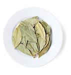 Aromatic bay leaves on plate. Isolated on white background
